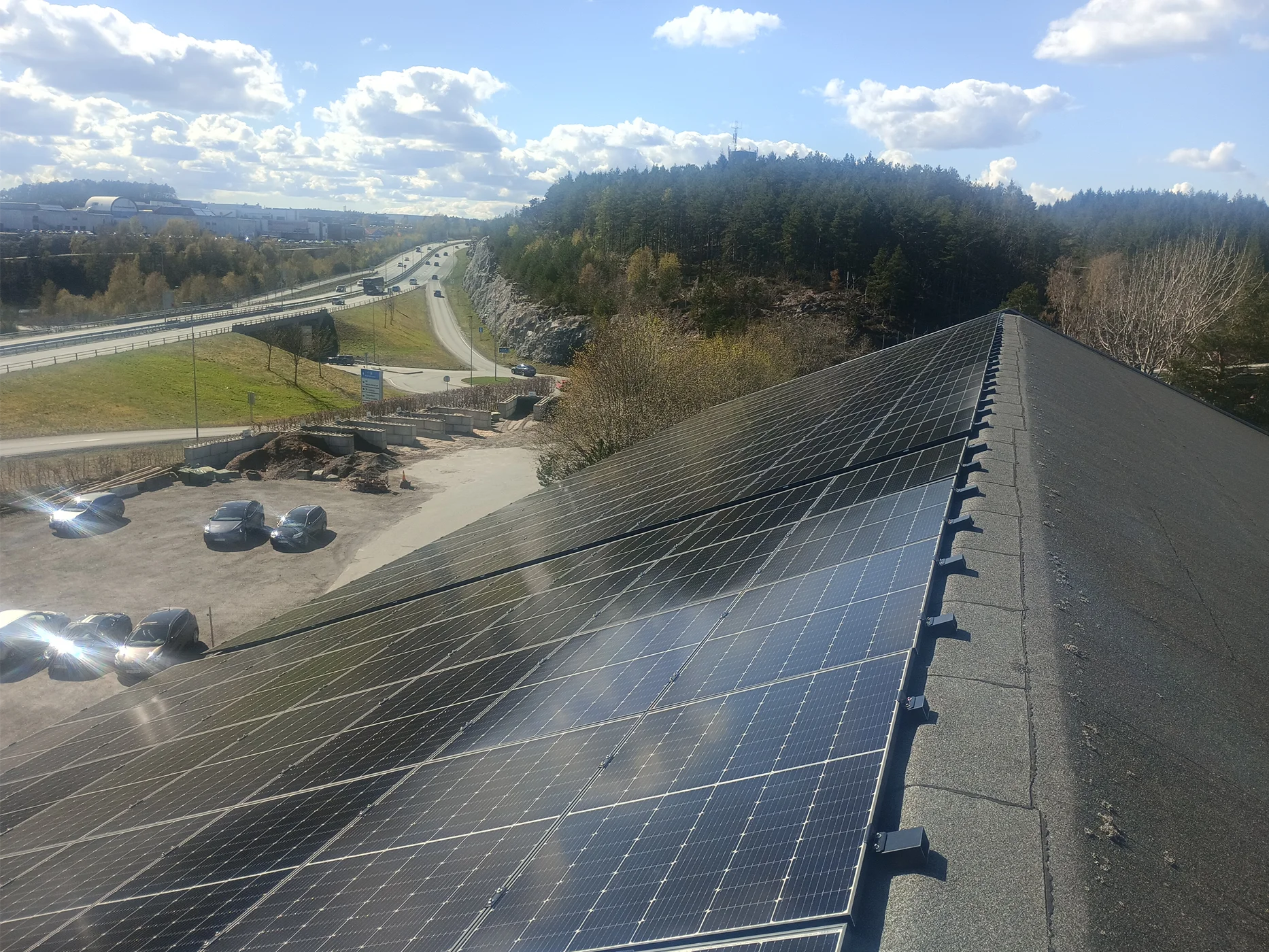 Solar panel array on industrial rooftop with landscape