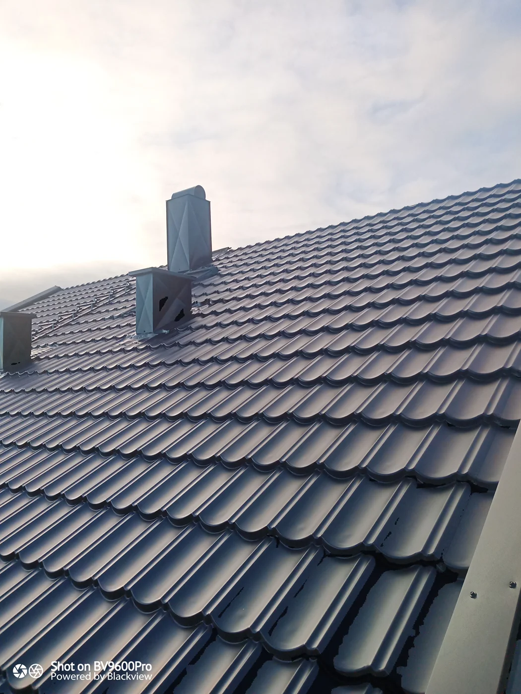 Modern metal roof installation with ventilation stacks