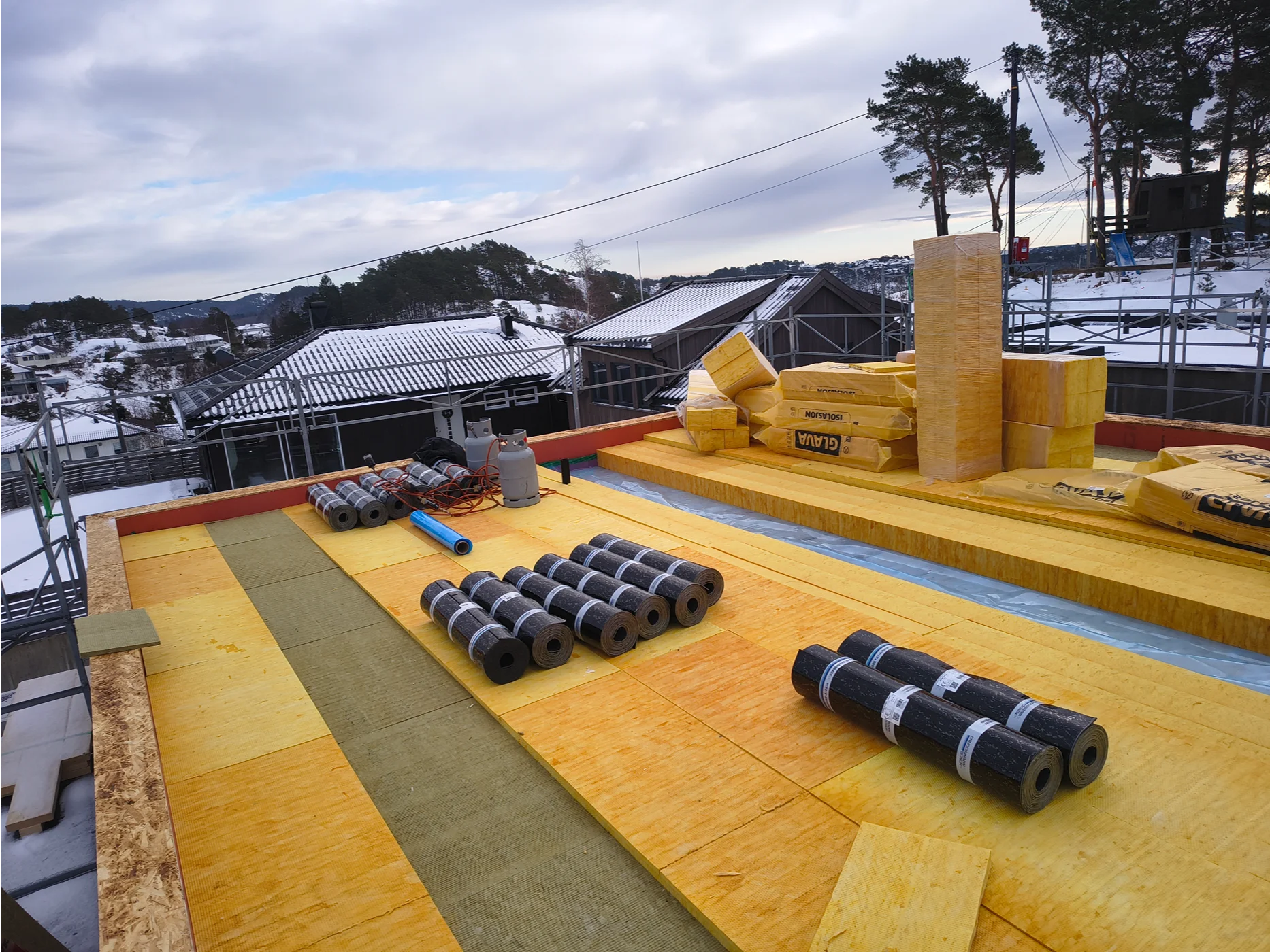 Roofing installation project with waterproofing membrane rolls