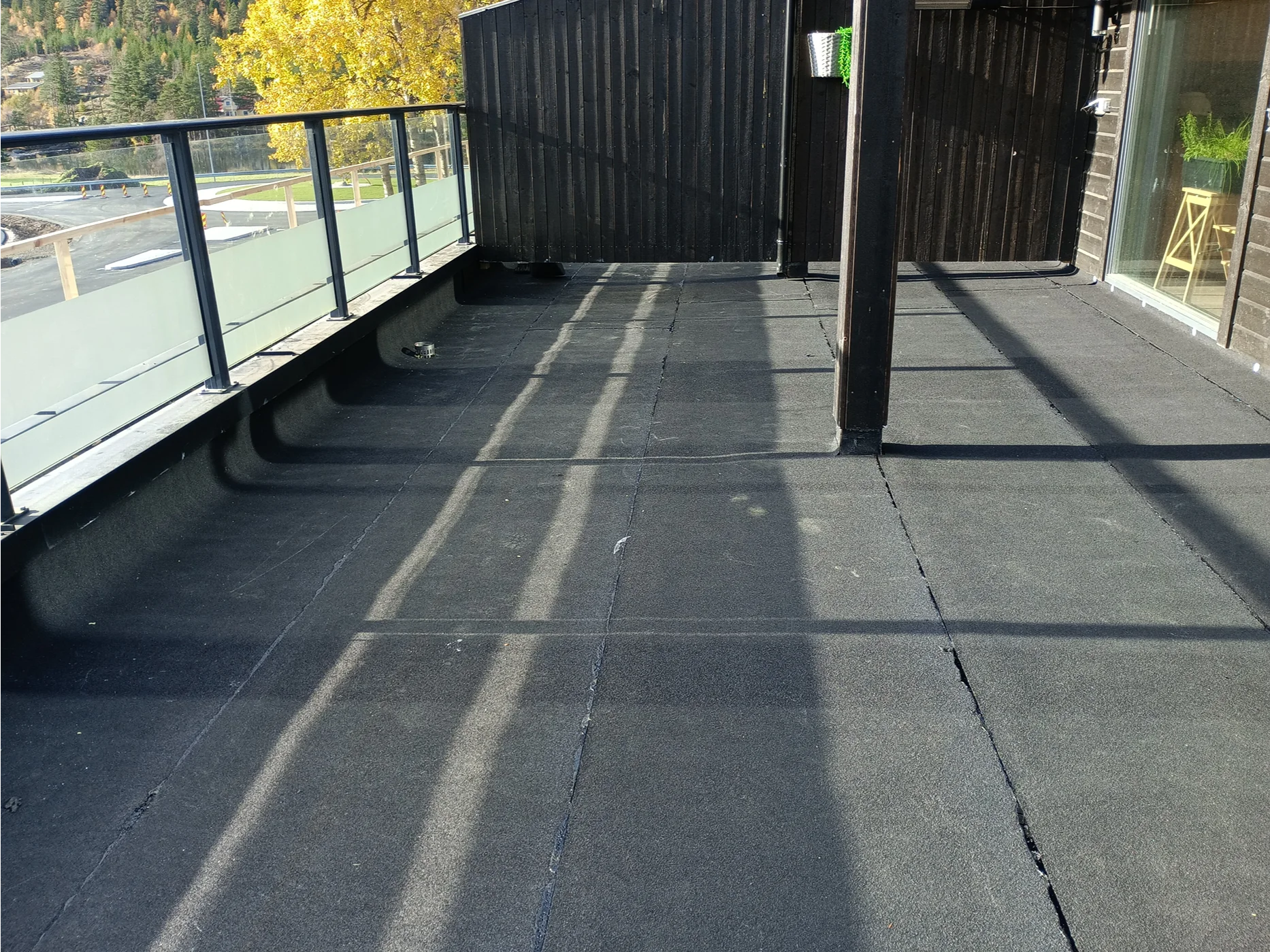 Modern terrace with dark rubber flooring and railings