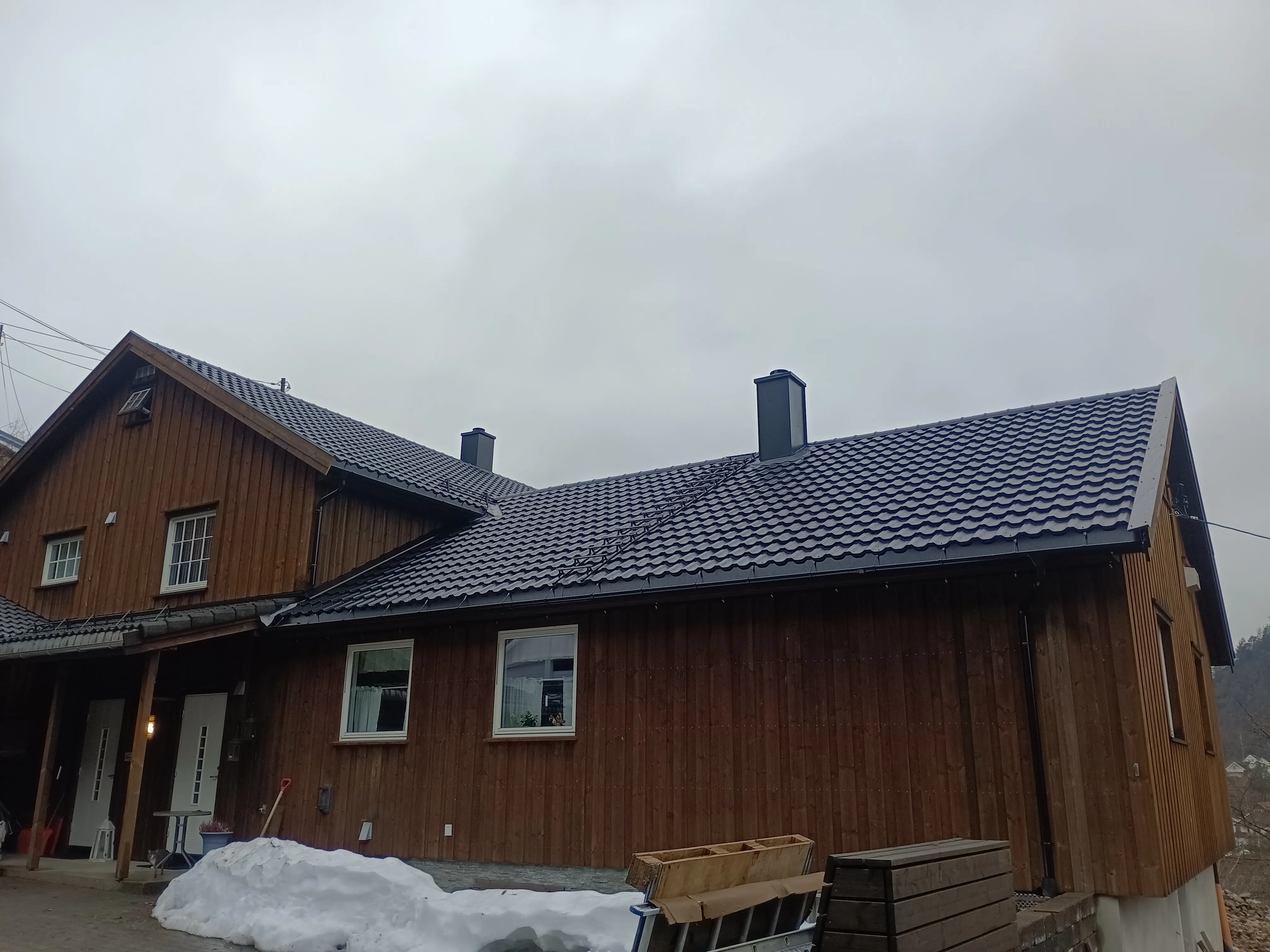 Vakkert skifertak installert på en trehus med røykventiler