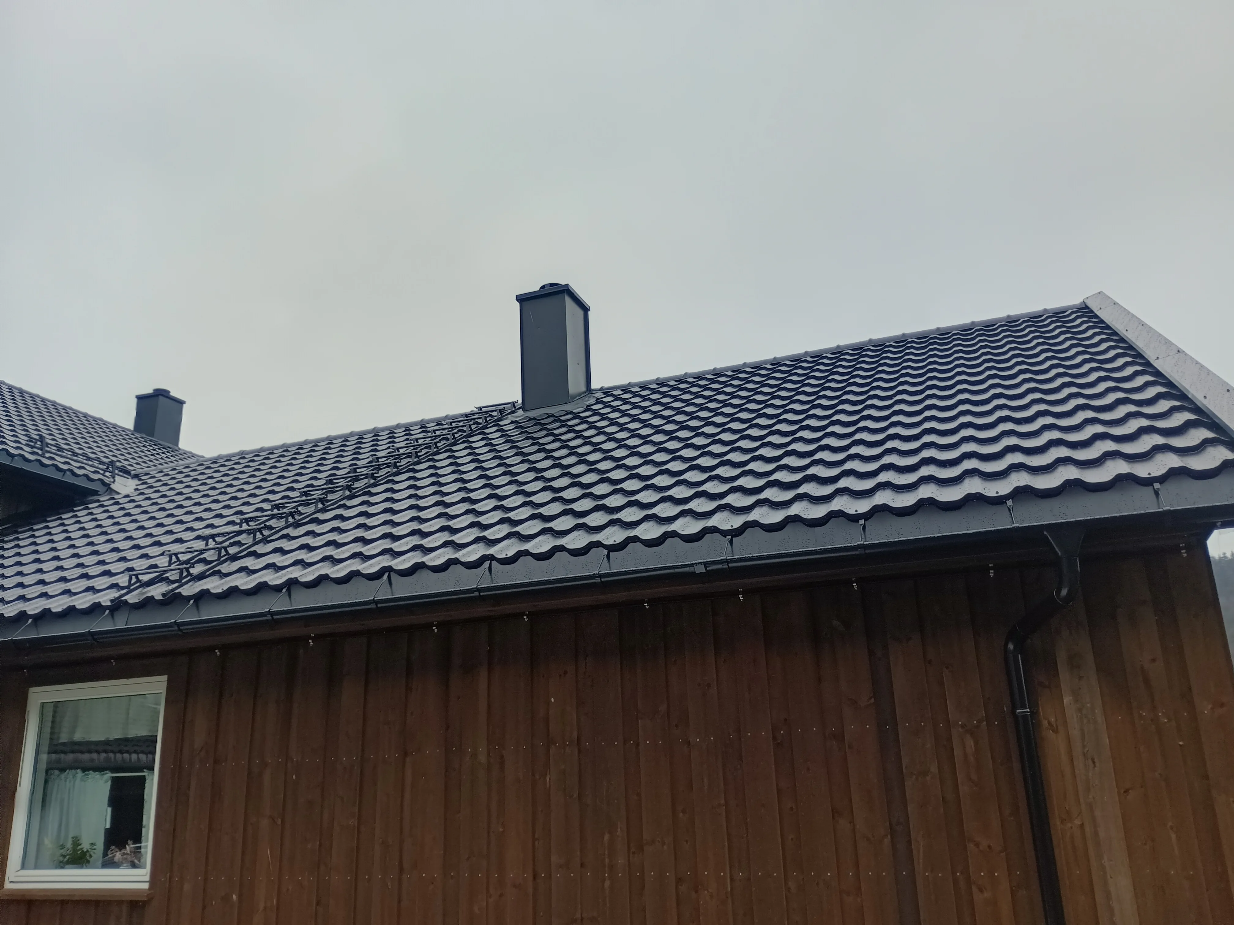Nytt tak med takstein og pipebeslag på en bolig