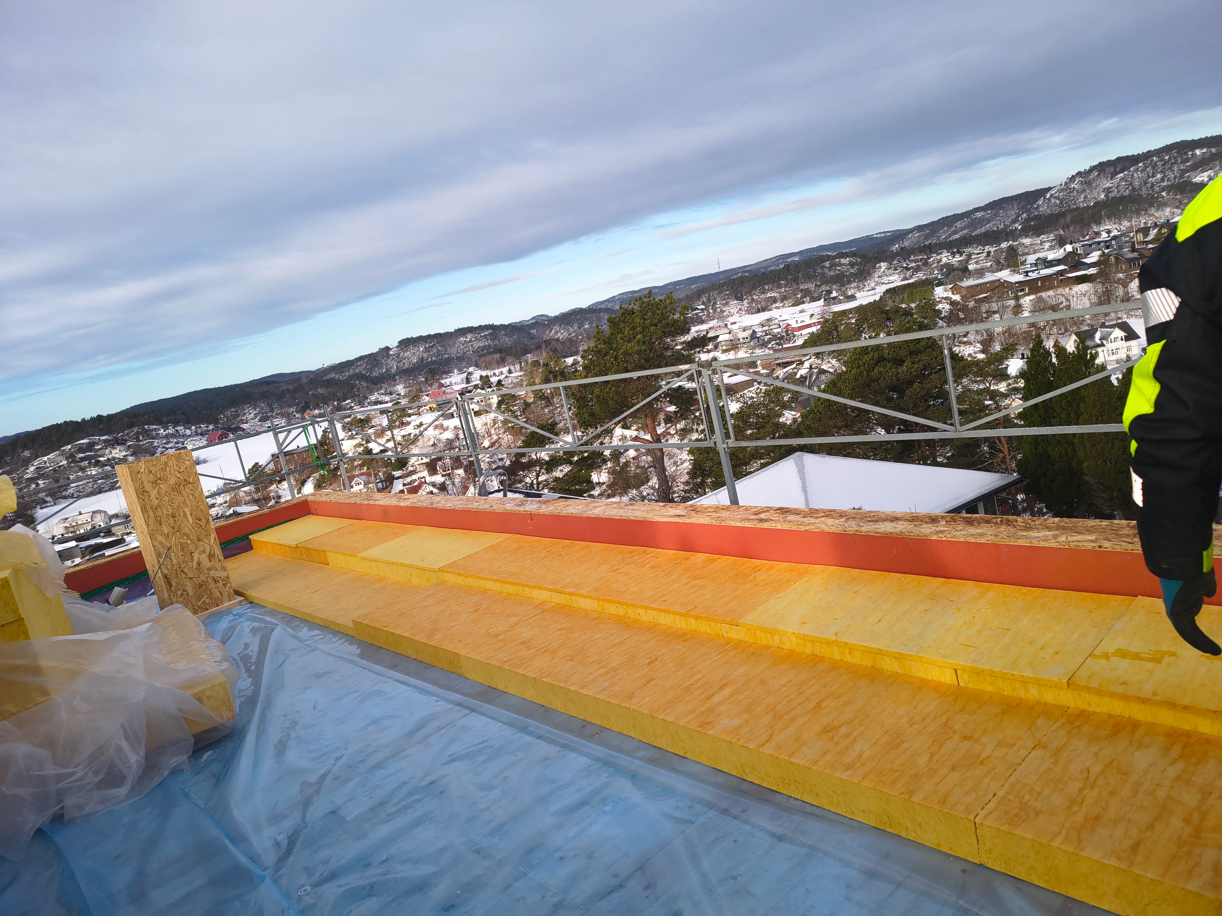 Montering av takisolasjon på skråtak med utsikt over landskapet