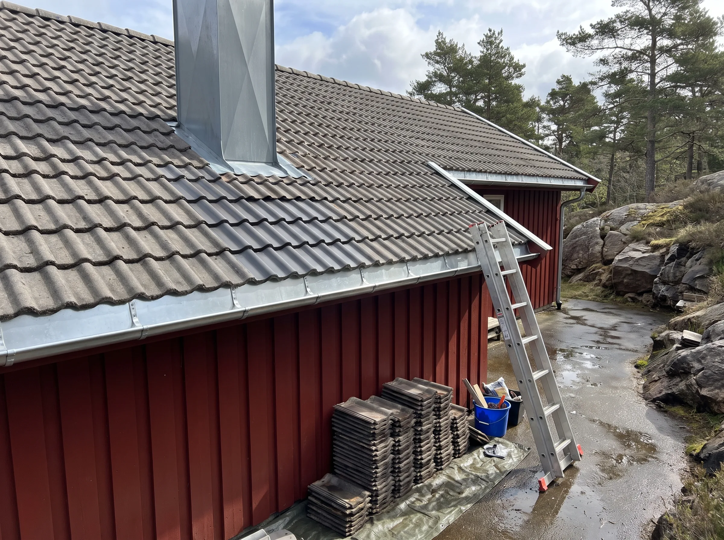 Montering av takstein på hytte med stige og skorstein i bakgrunnen