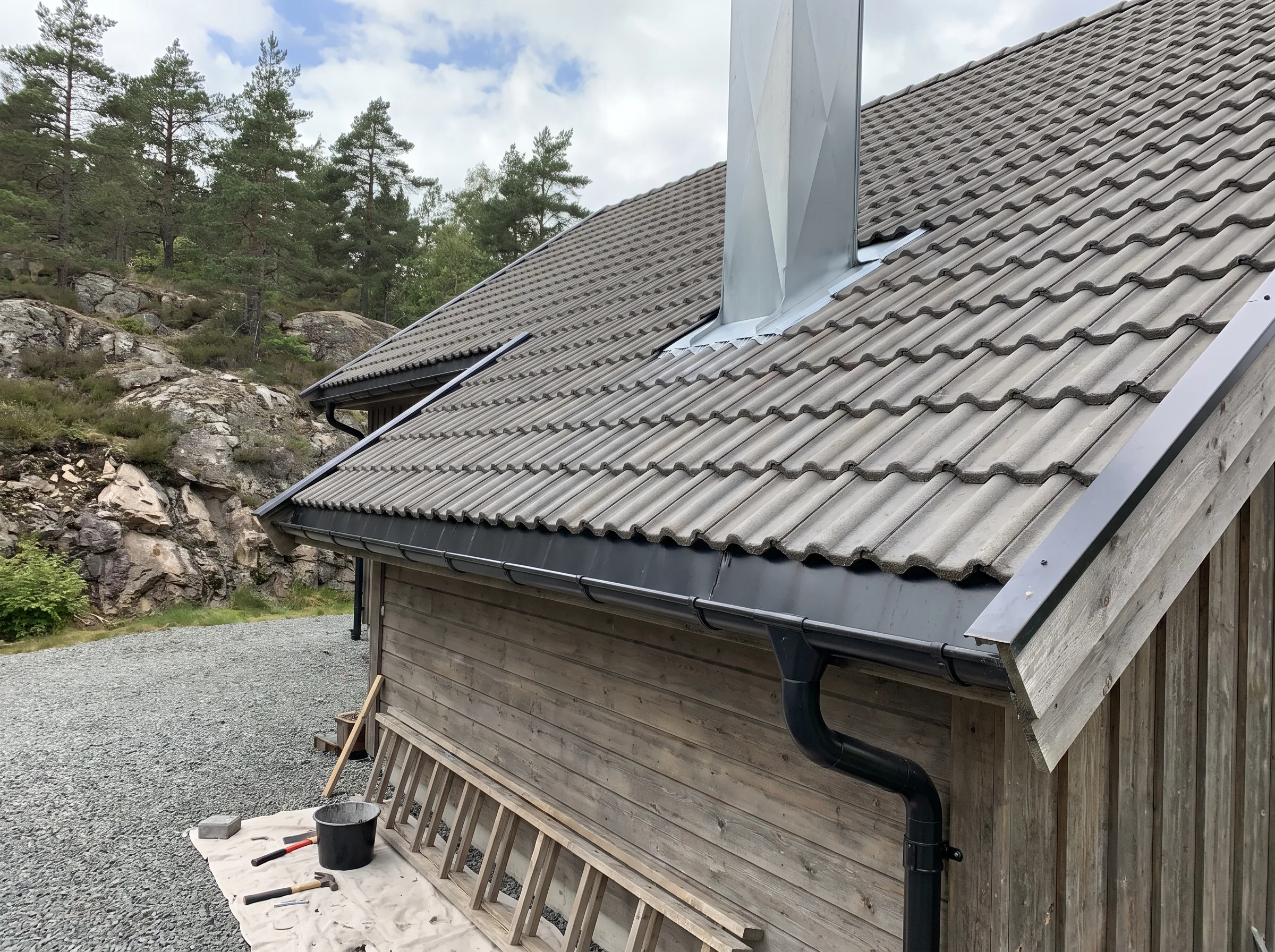 Taktekkerarbeid med takstein og pipebeslag på et fritidshus