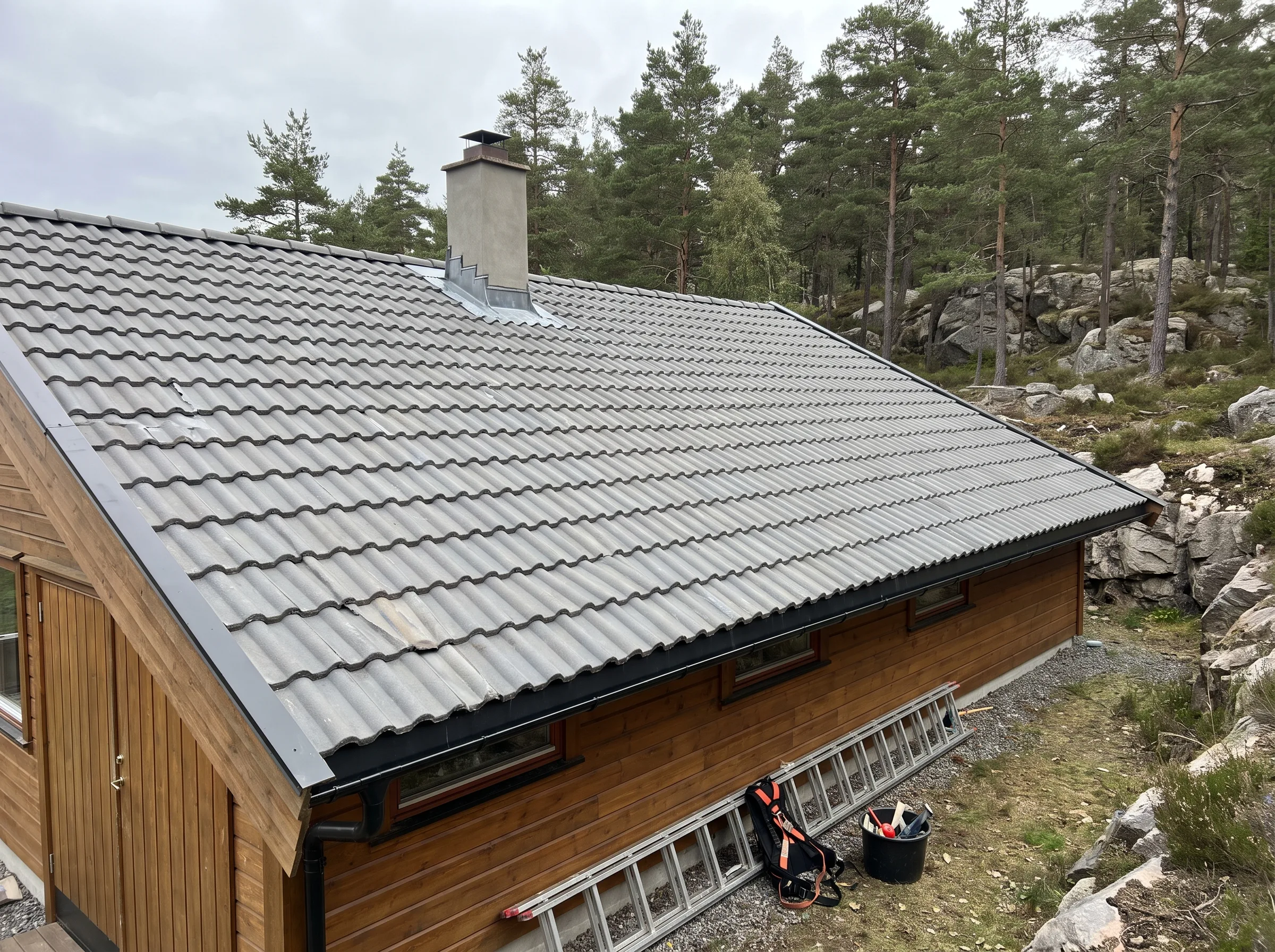 Takstein på skråtak med pipe og naturskjønt bakgrunn