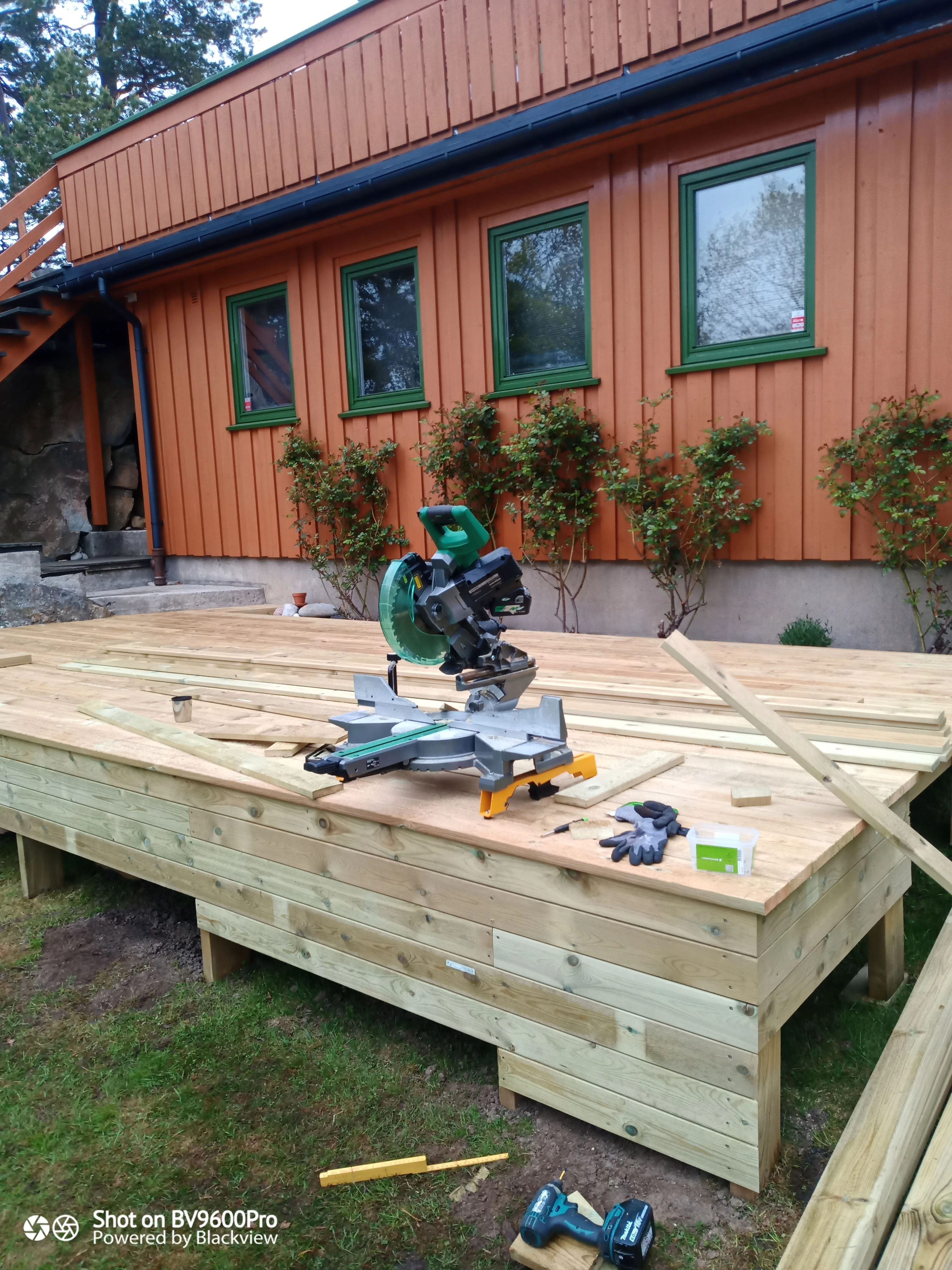 Utsikt over en byggeplass med treplater og sager for terrassekledning