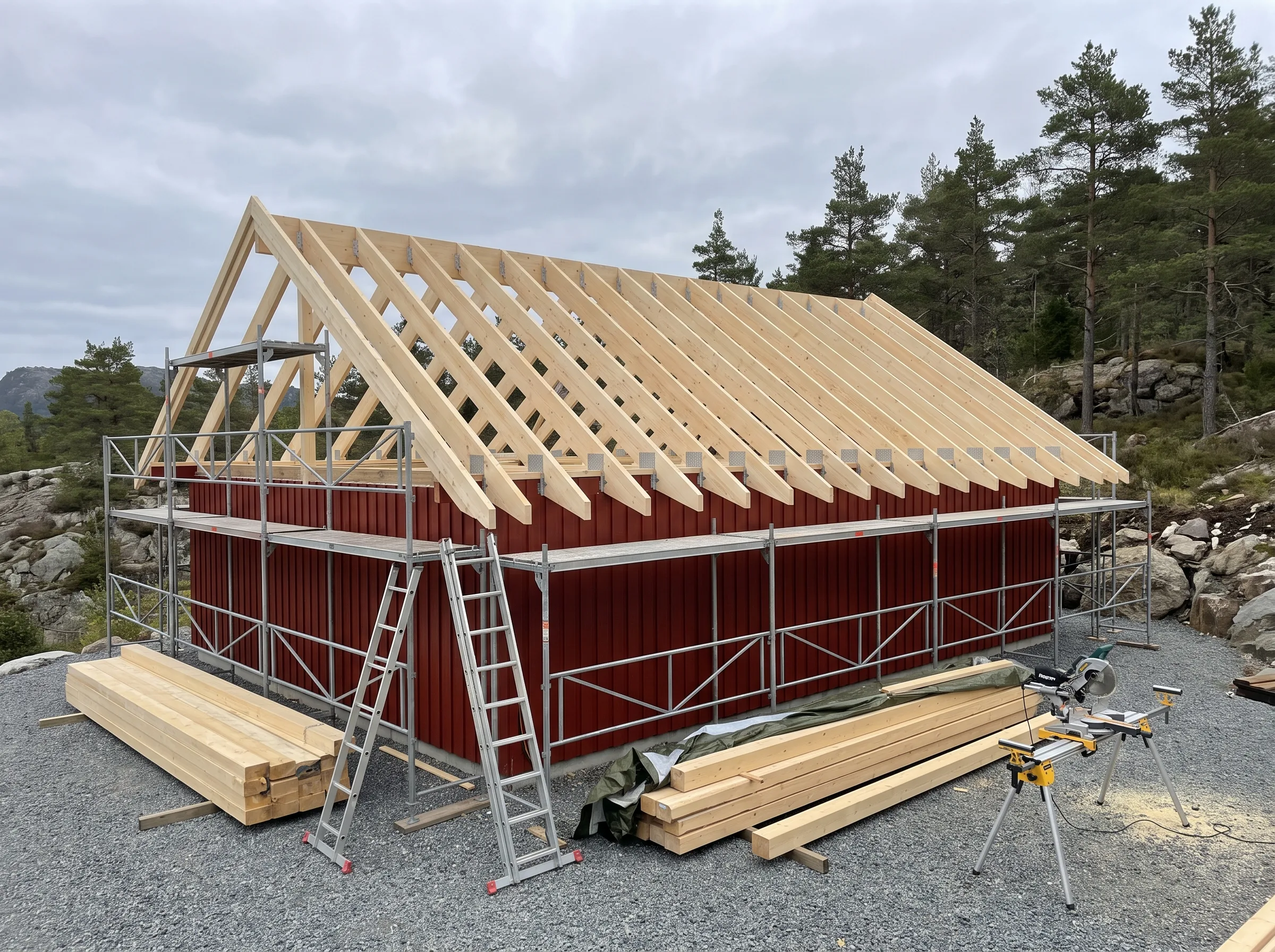Montering av takkonstruksjon med trestendere på rød bygning i naturområde