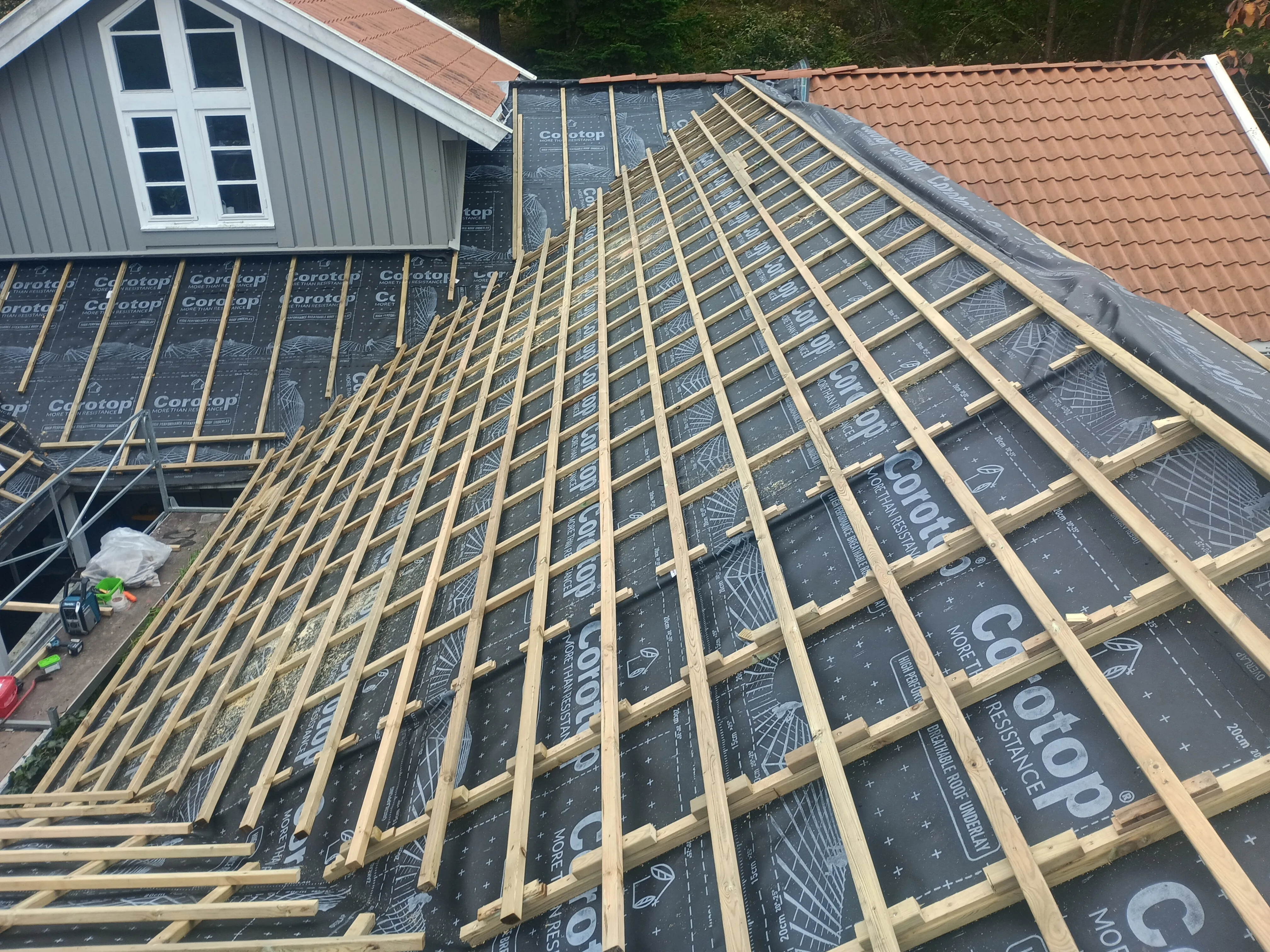 Skråtak med trestillas og takpapp før fliselegging