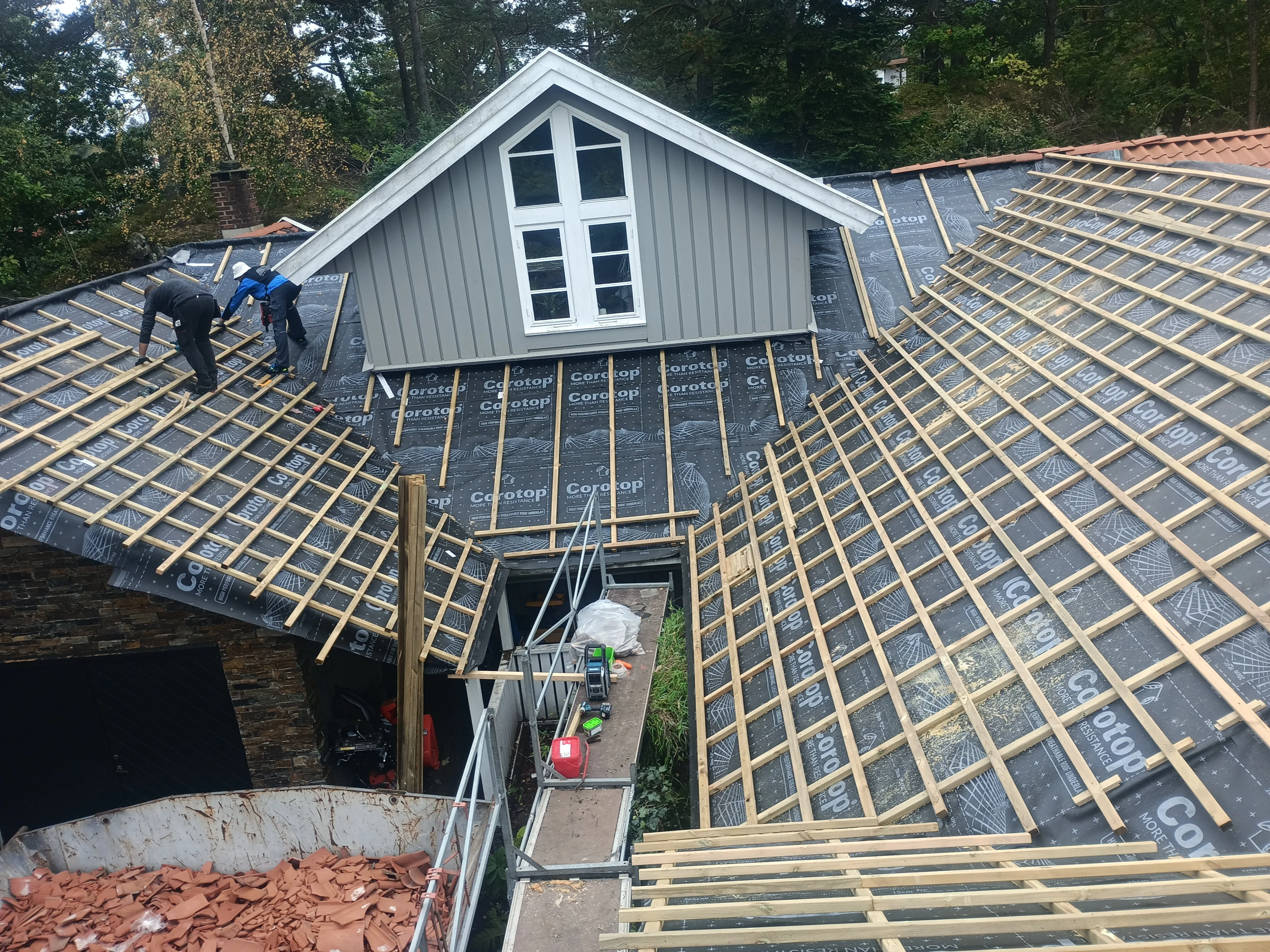 Takomlegging på skråtak med håndverkere i arbeid